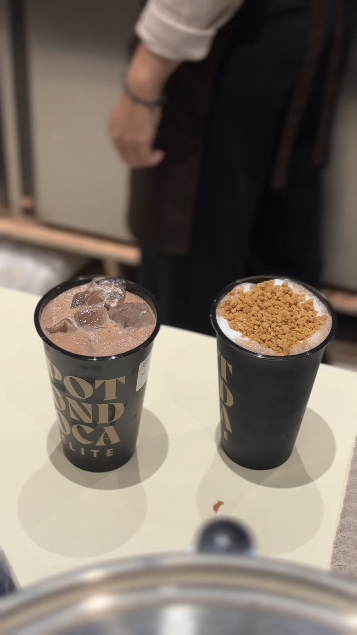 Dua cup Potondoca Elite dengan topping di atas meja